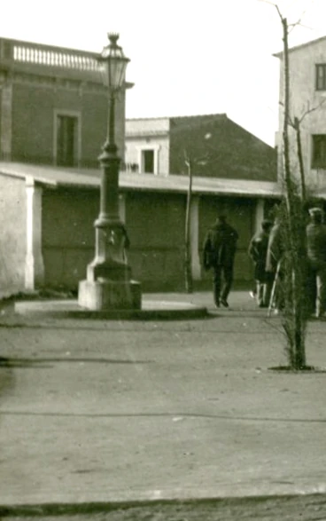 Fotografía antigua de una calle con una fuente y varios edificios